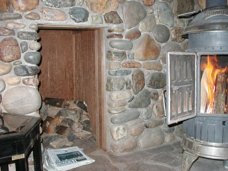 A little firewood storage area next to the stove