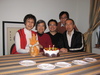 Family arrayed behind the cake (camera was perched precariously on a box on some stacked chairs)