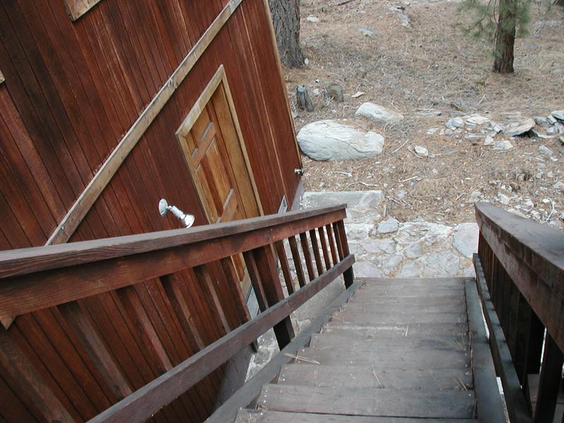 Down the back stairs of the rear deck, with the crawl space door to the left